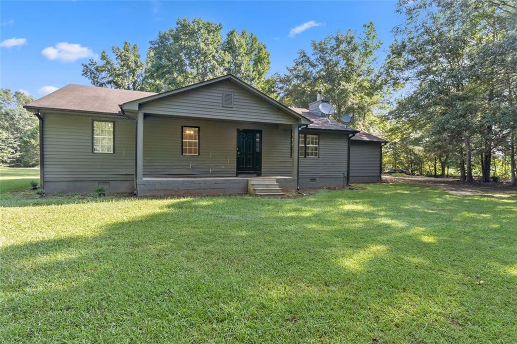 a brick house next to a yard with large trees