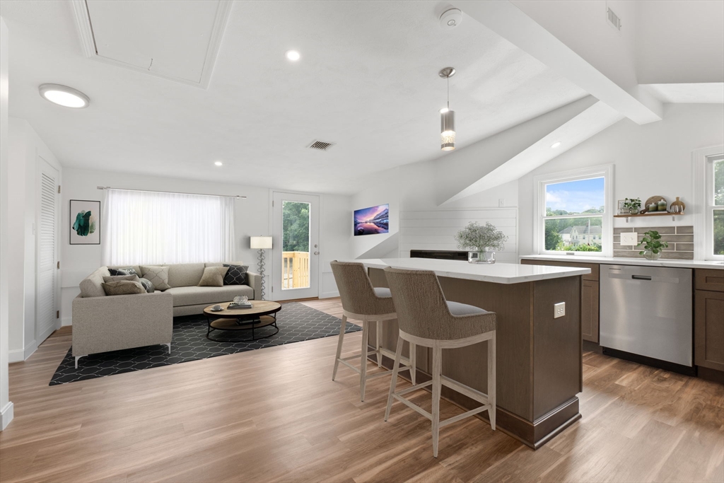 a living room with furniture a dining table wooden floor and a sink