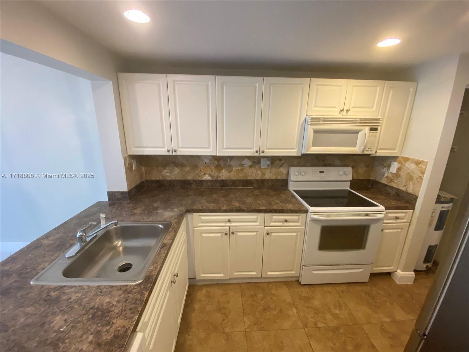 a kitchen with a sink stove and cabinets