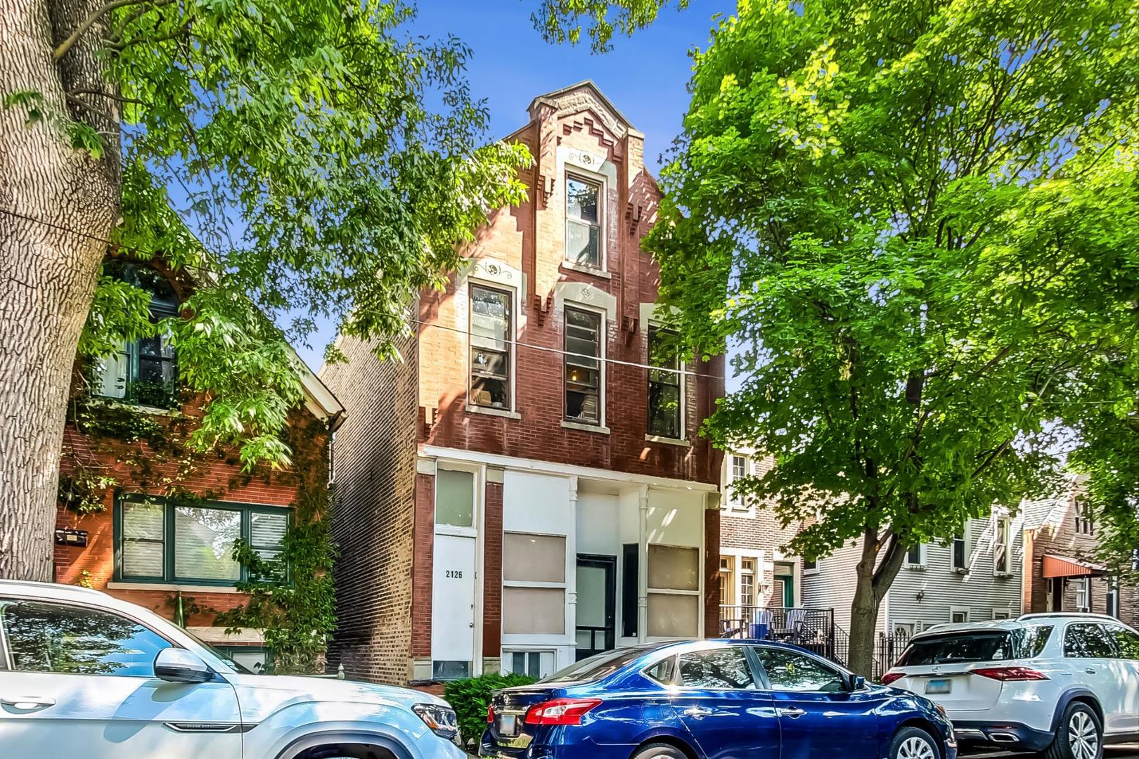 a couple of cars parked in front of brick building