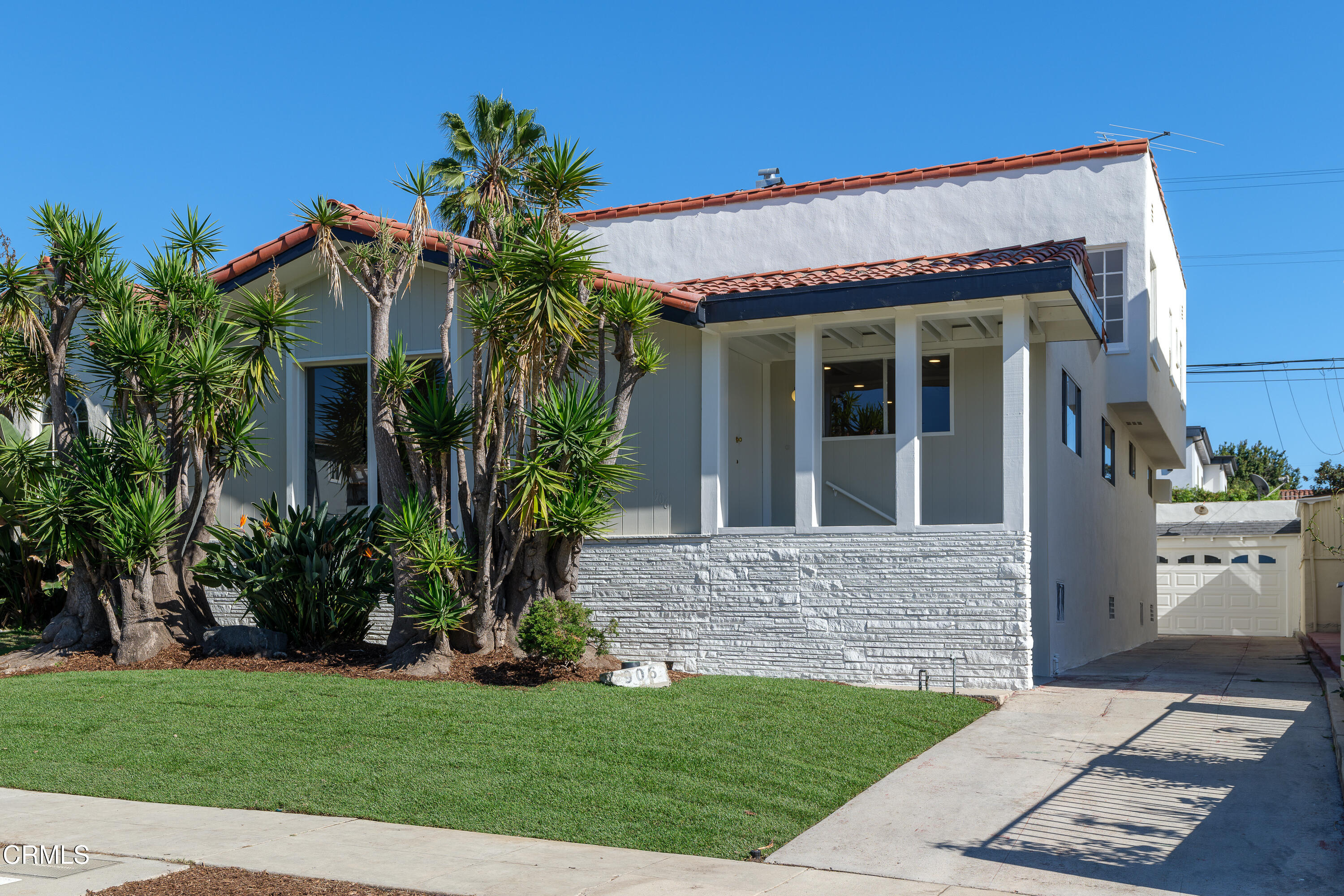 a view of a house with potted plants and a yard