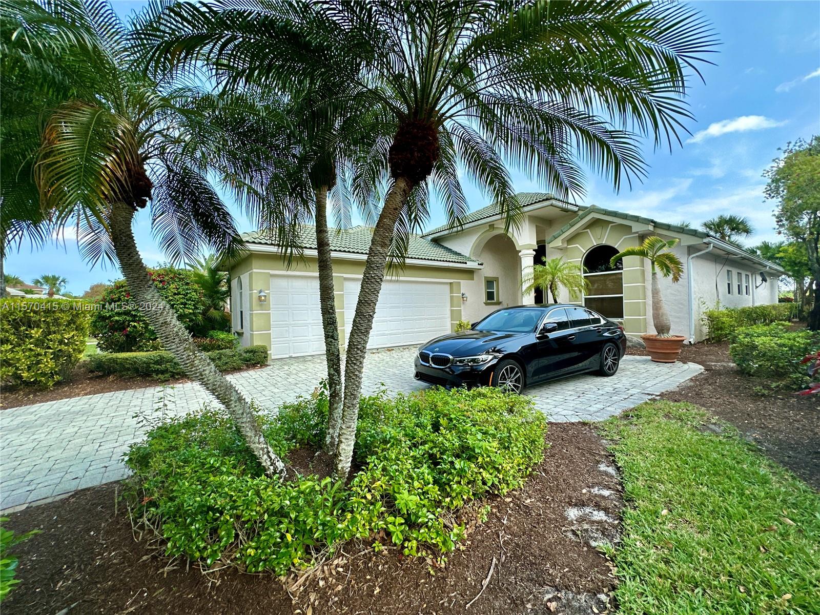 a couple of palm trees sitting in front of a house