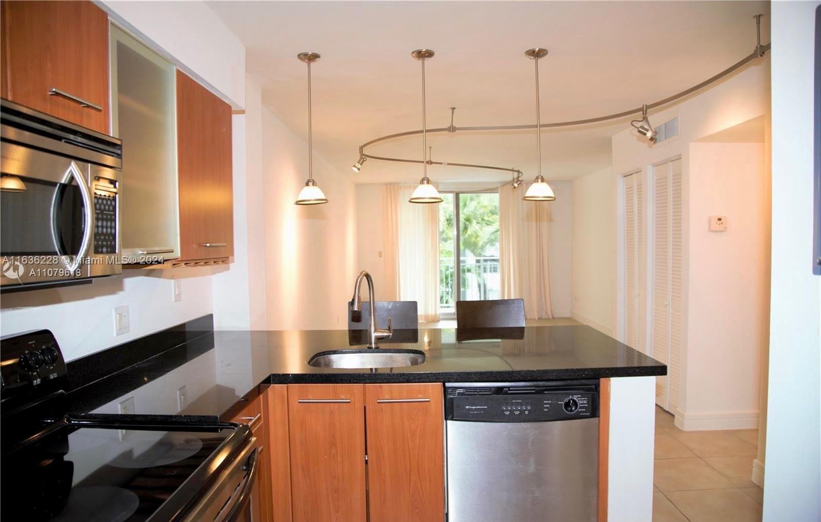 a kitchen with stainless steel appliances granite countertop a sink a stove and a refrigerator