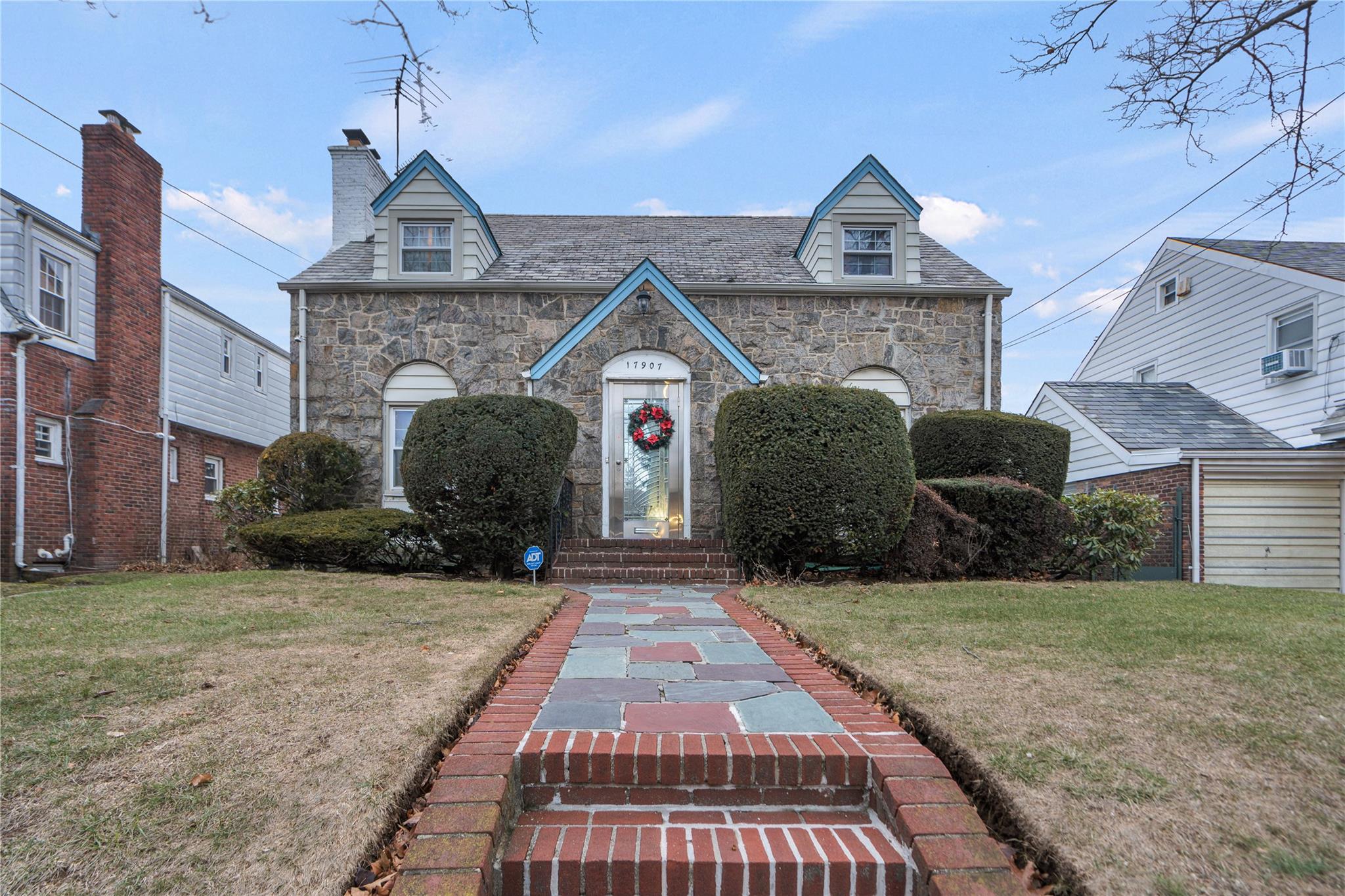 View of front facade featuring cooling unit and a front yard