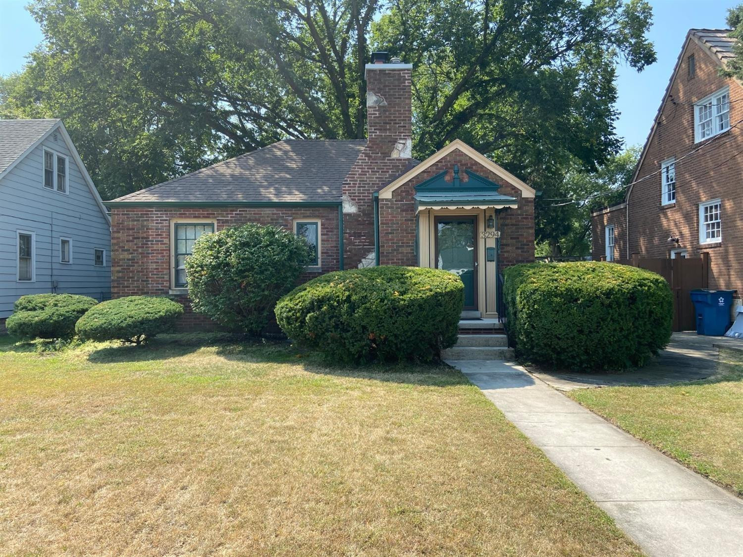 a view of a house with a yard and large trees