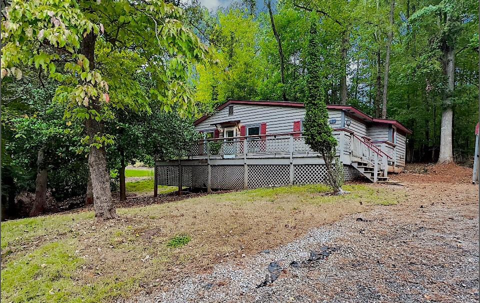 a view of a house with a backyard and trees