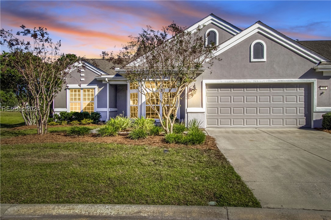 View of front of house featuring a yard and a gara