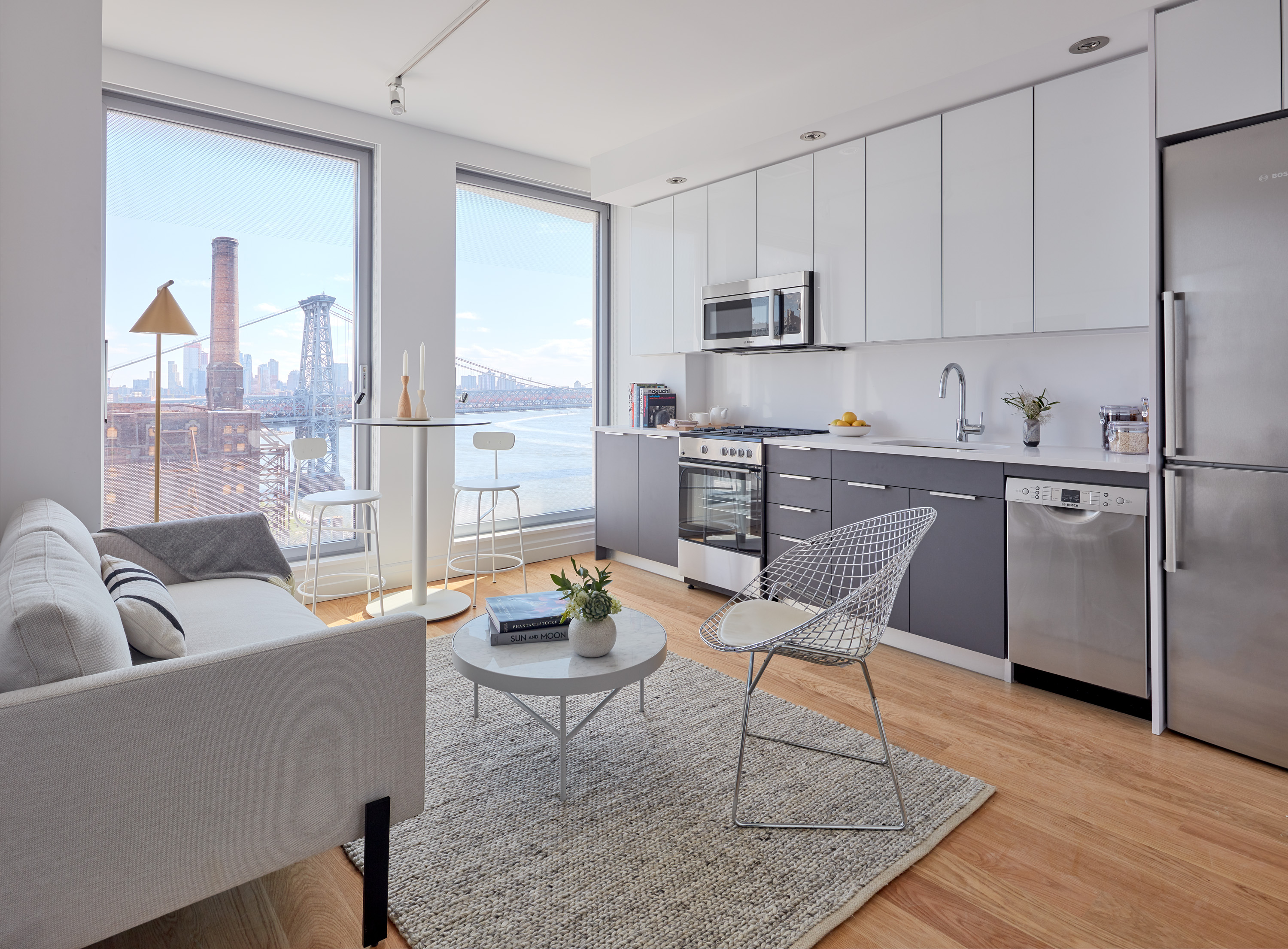 a living room with furniture a rug and kitchen view