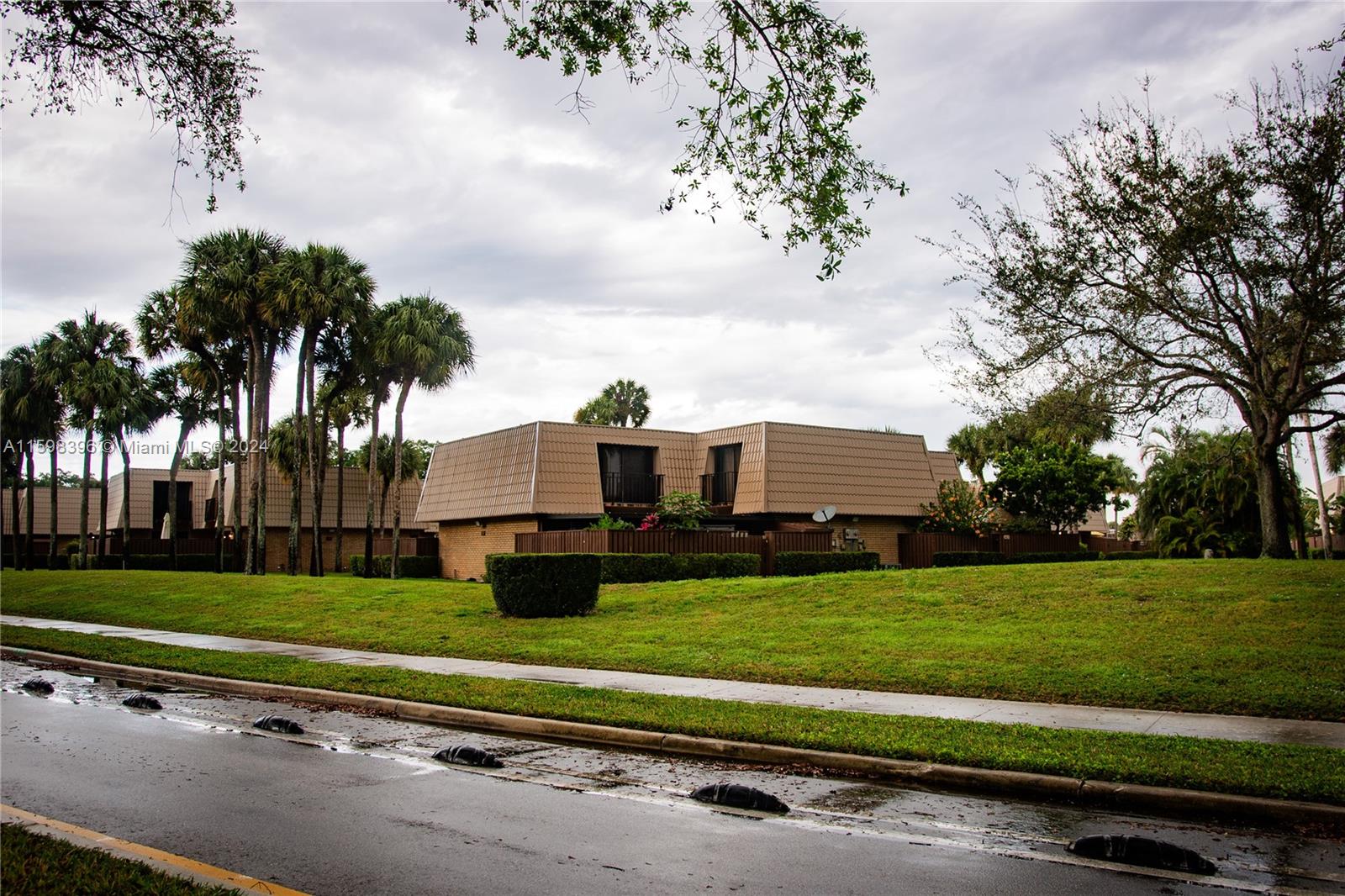 a front view of a house with a garden and trees