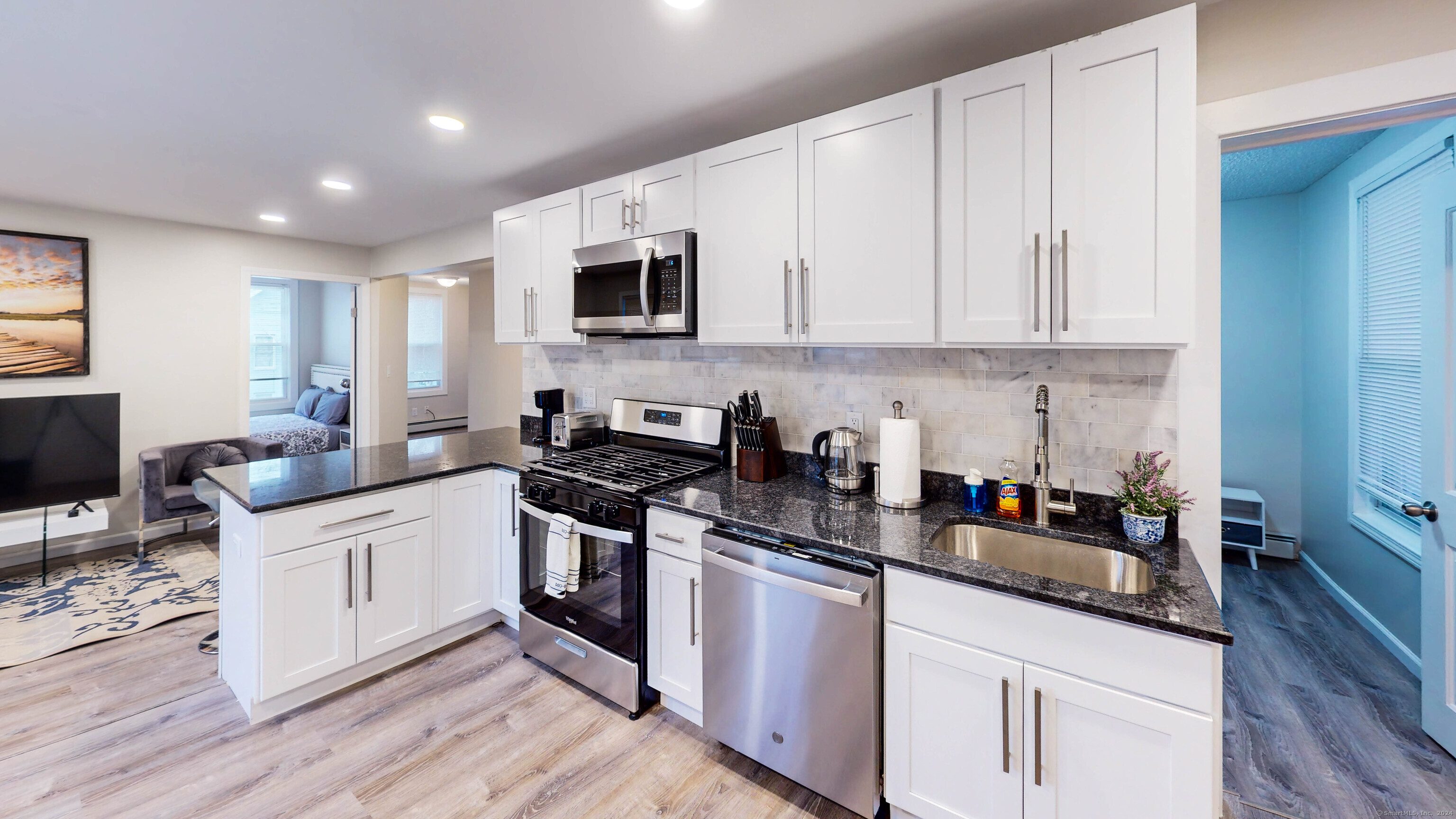 a kitchen with white cabinets and appliances