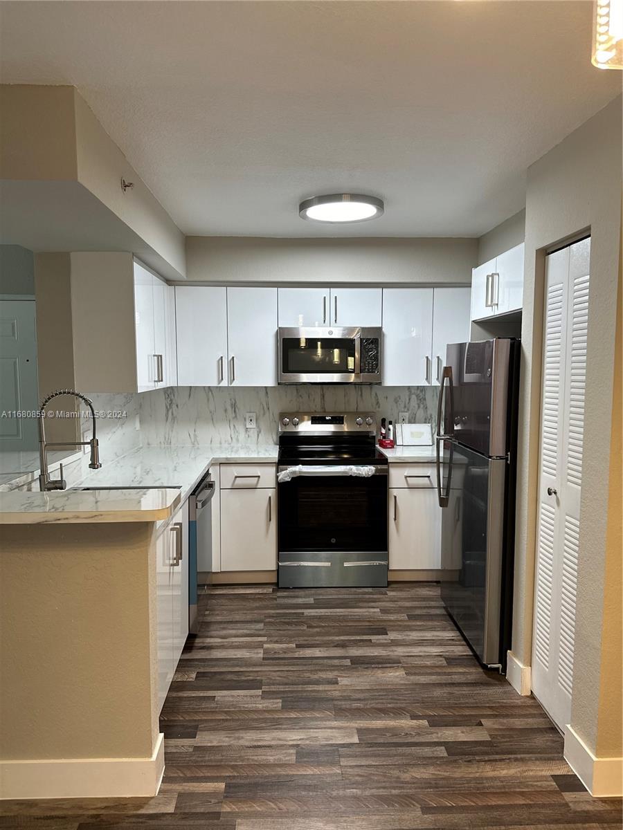 a kitchen with a sink stainless steel appliances and cabinets