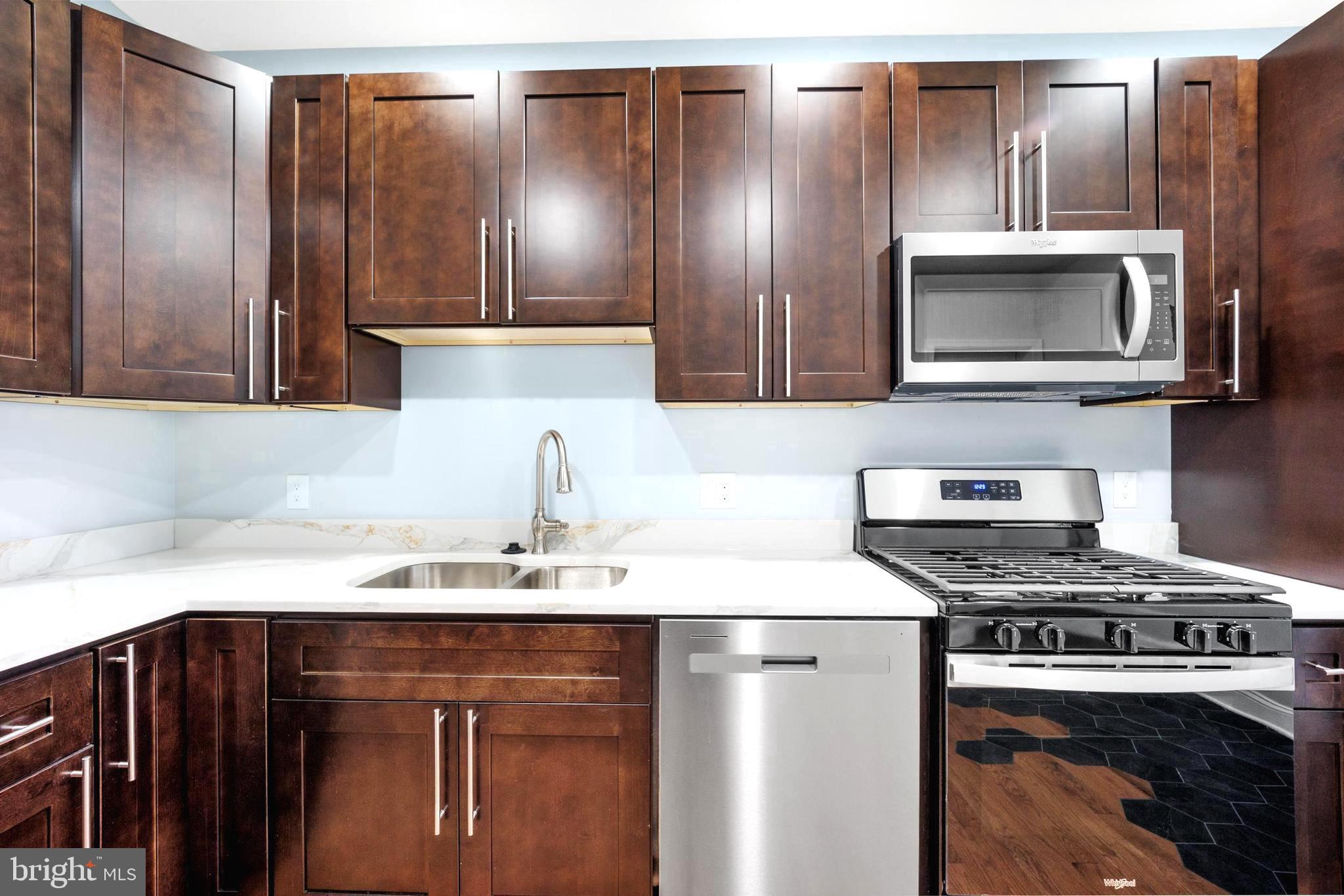 a kitchen with stainless steel appliances a sink stove and refrigerator