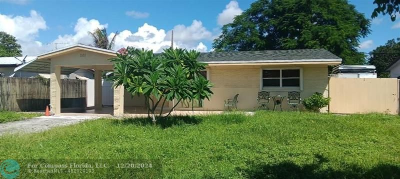 a view of a house with a yard and potted plants