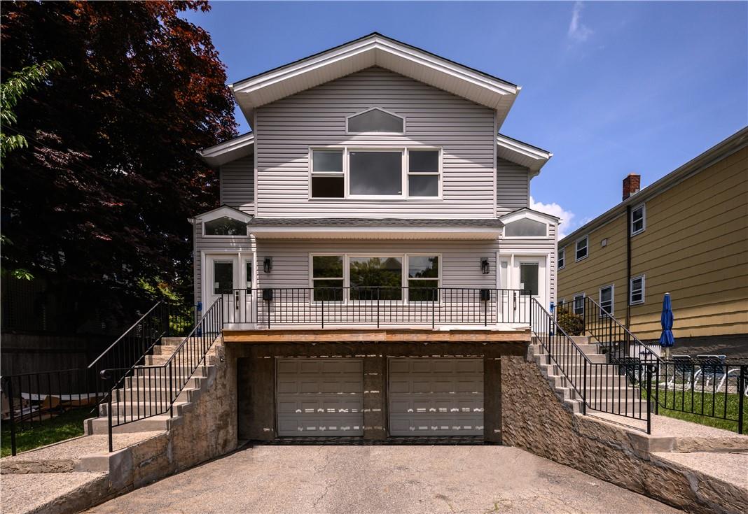 a front view of a house with yard and parking