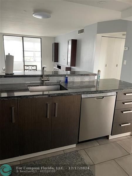 a kitchen with a sink window and cabinets