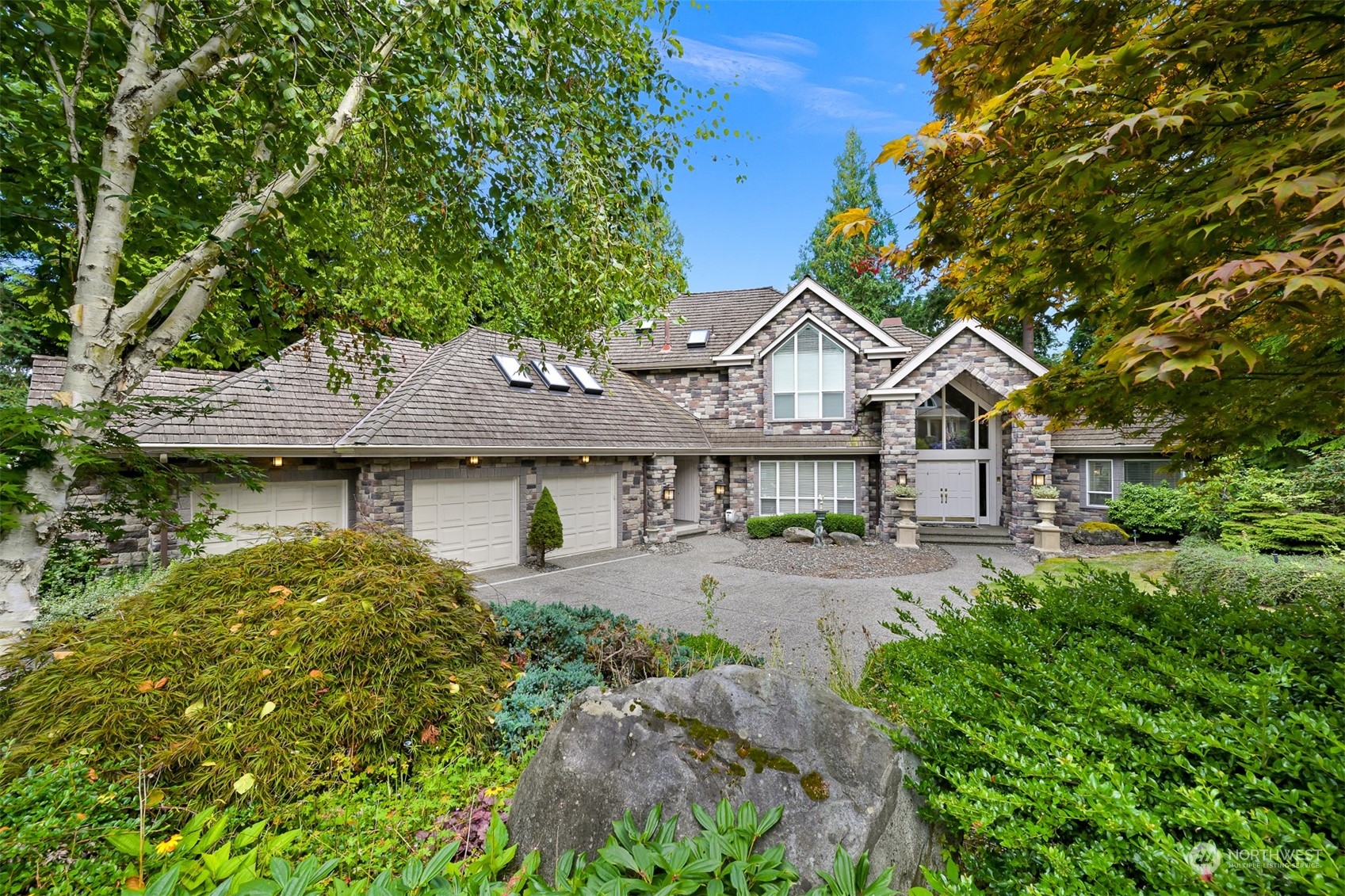 a front view of a house with yard and green space