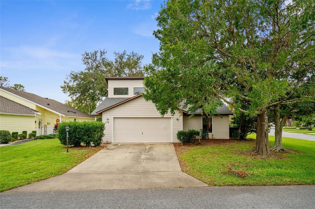 a front view of a house with a yard and trees