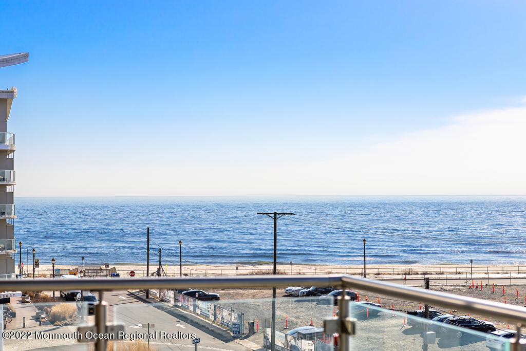 a view of roof with building and ocean view