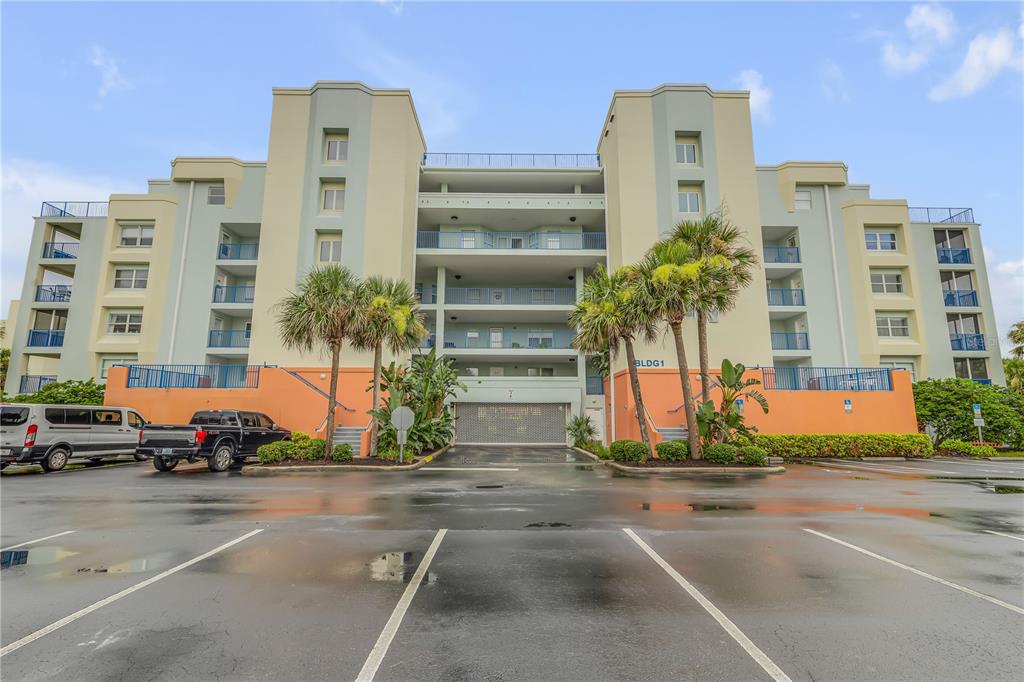 a front view of a building with palm trees