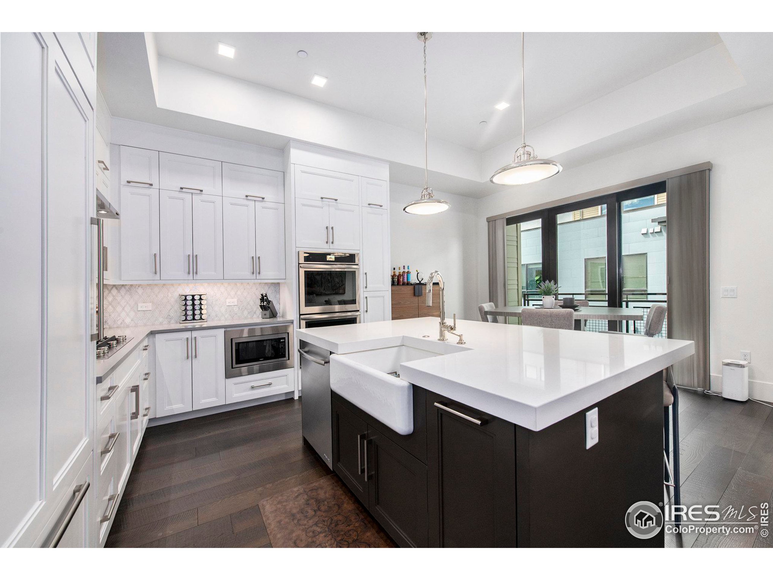 a large white kitchen with a sink and white appliances