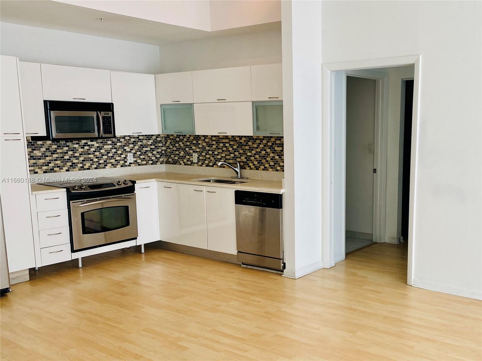 a kitchen with a stove and white cabinets