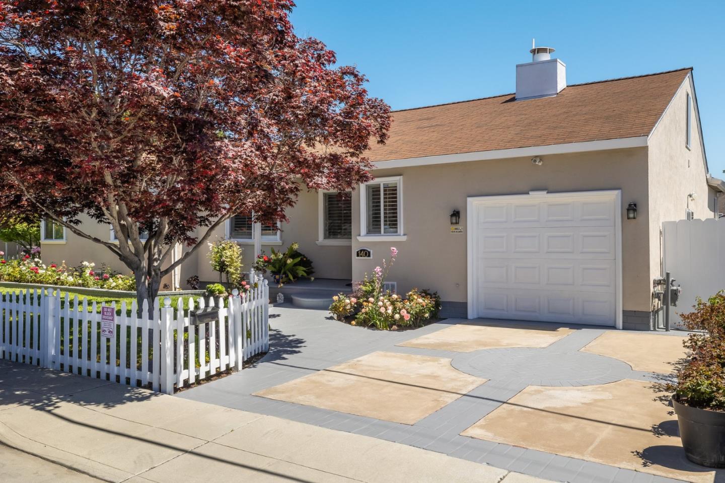 a front view of a house with a garden