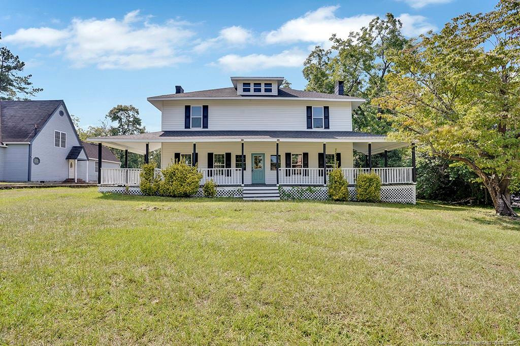 a front view of a house with a yard and lake view