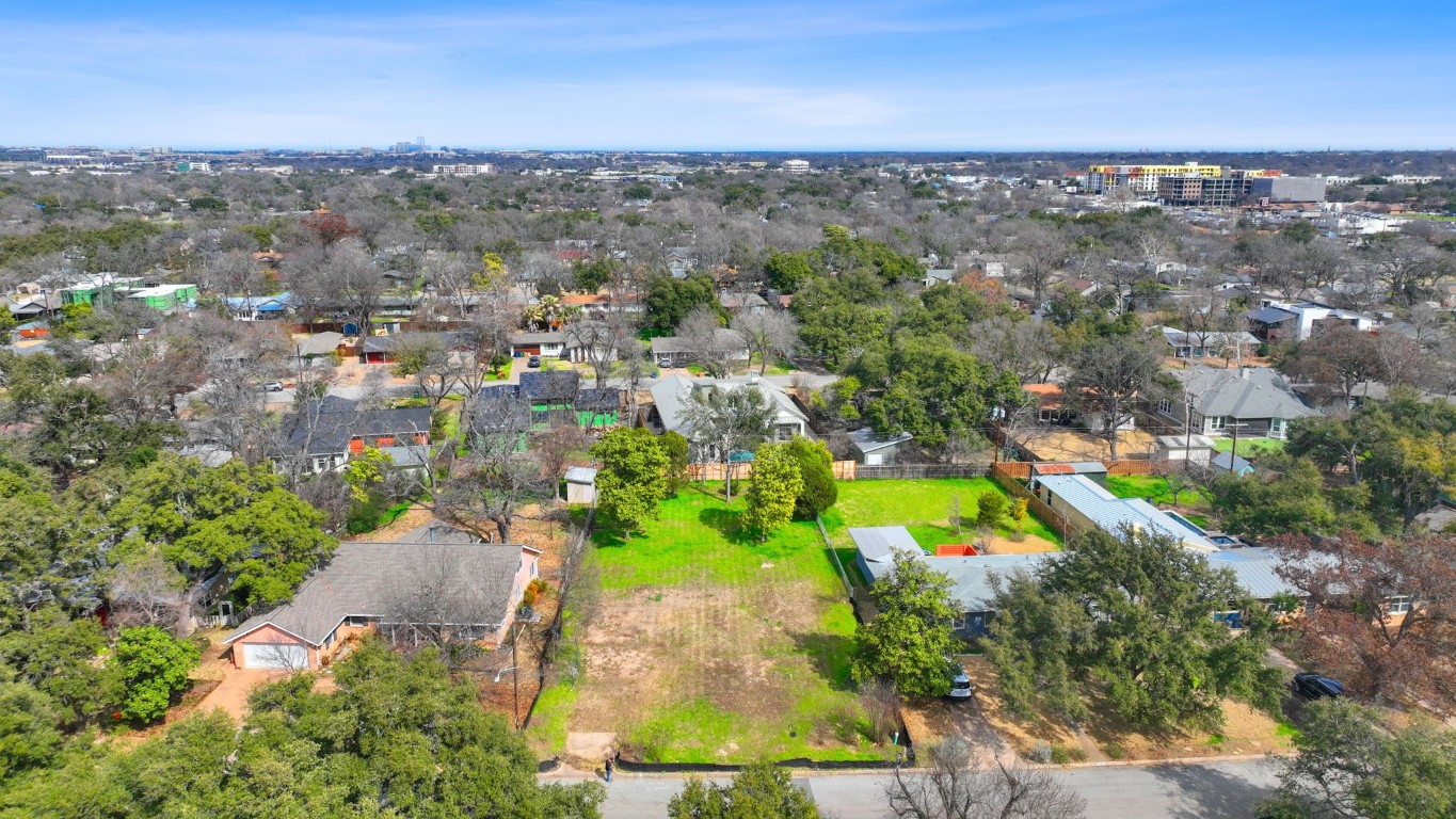 an aerial view of residential houses with outdoor space and trees