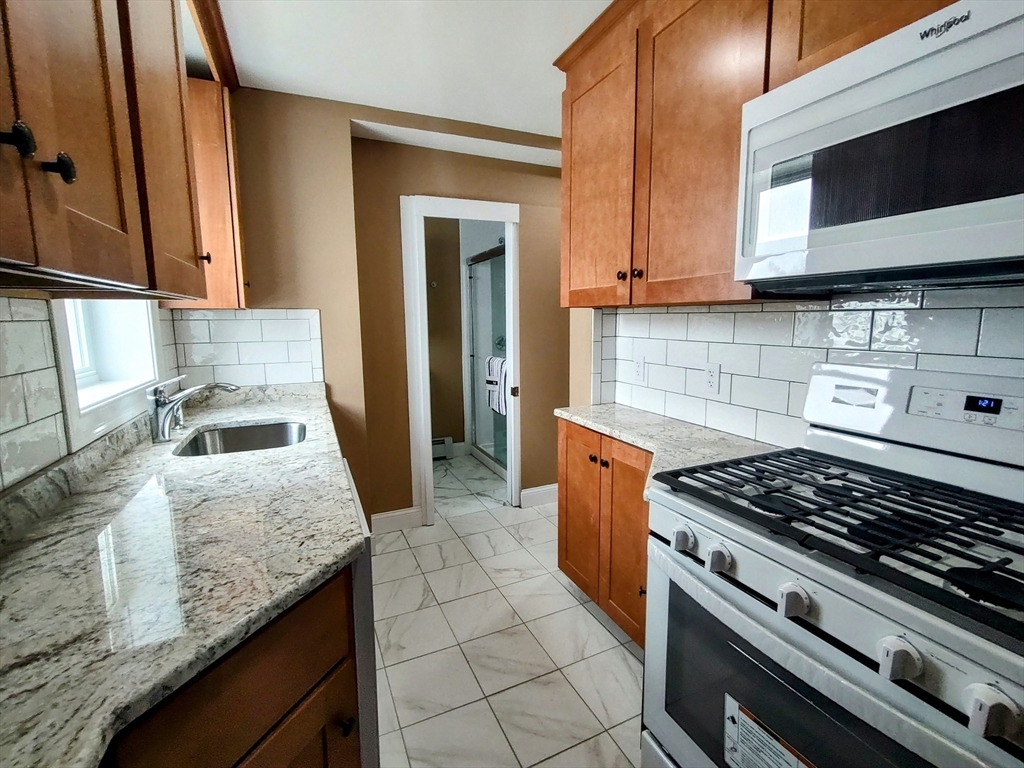 a kitchen with granite countertop a stove and a sink