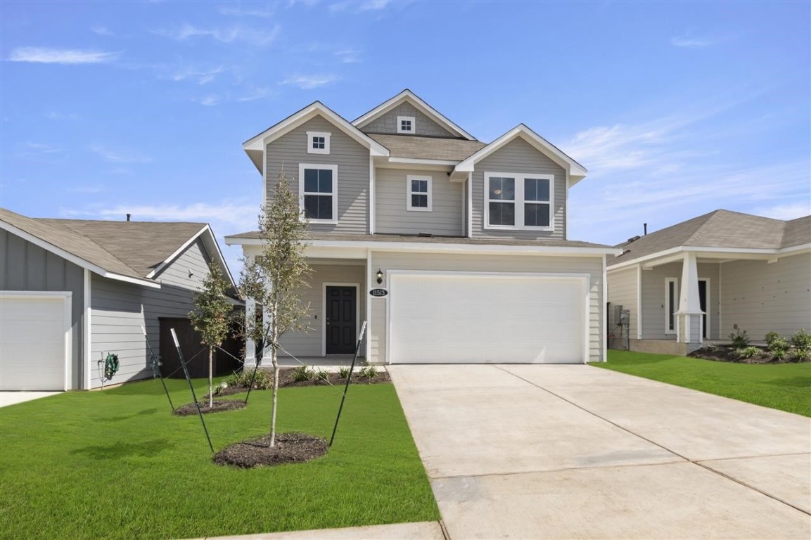 a front view of a house with a yard and trees