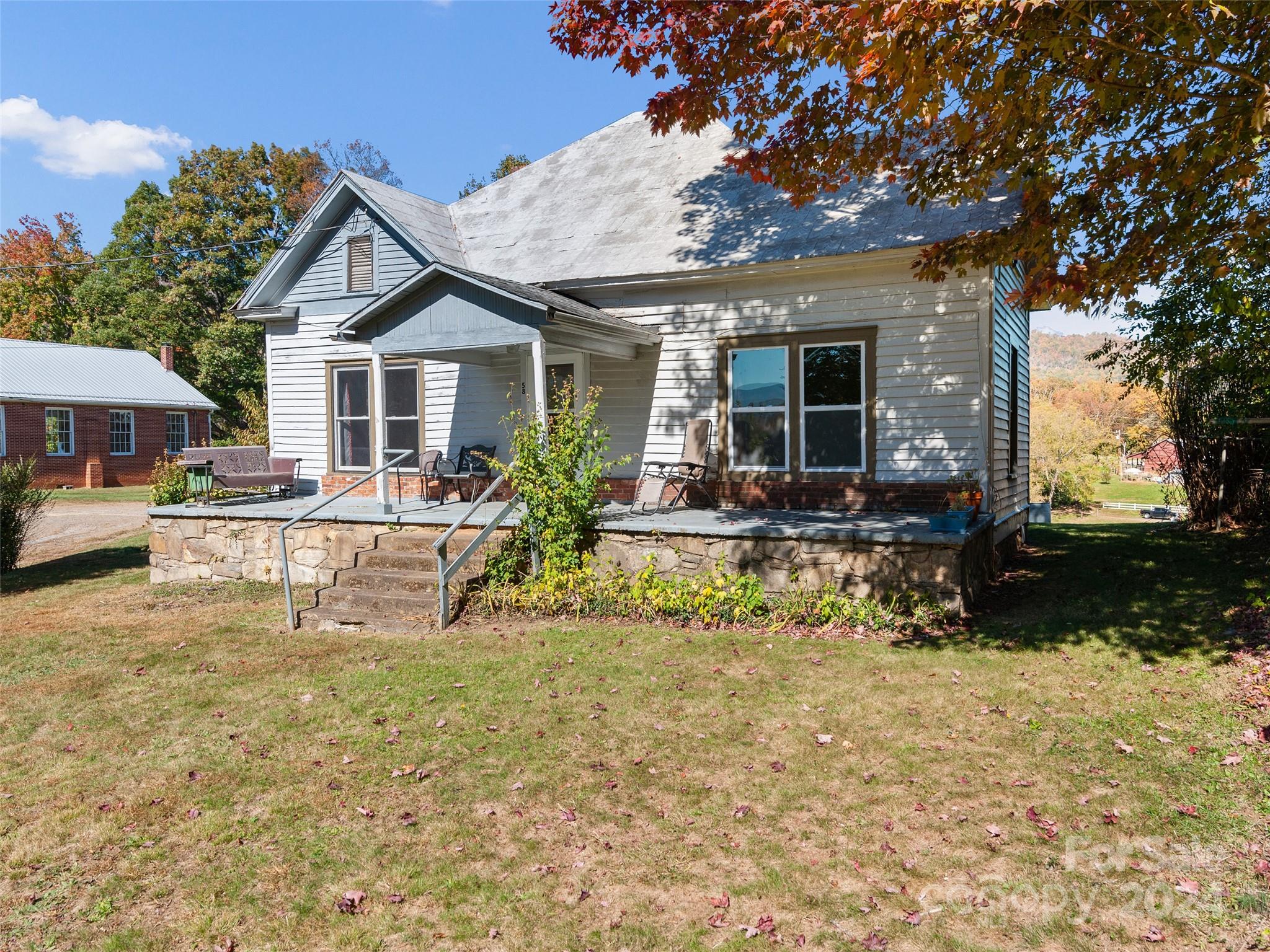 a view of a house with a yard patio and fire pit