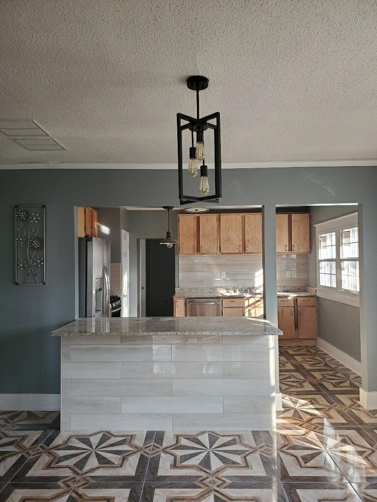 a large kitchen with kitchen island granite countertop a stove and a sink