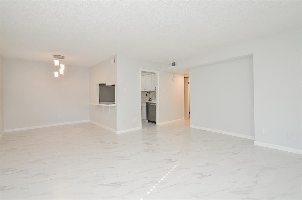 a view of an empty room with a kitchen