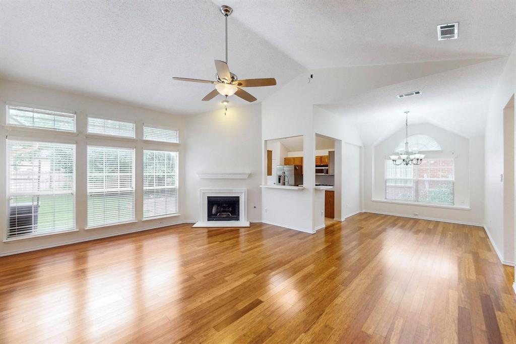 a view of empty room with wooden floor and fireplace