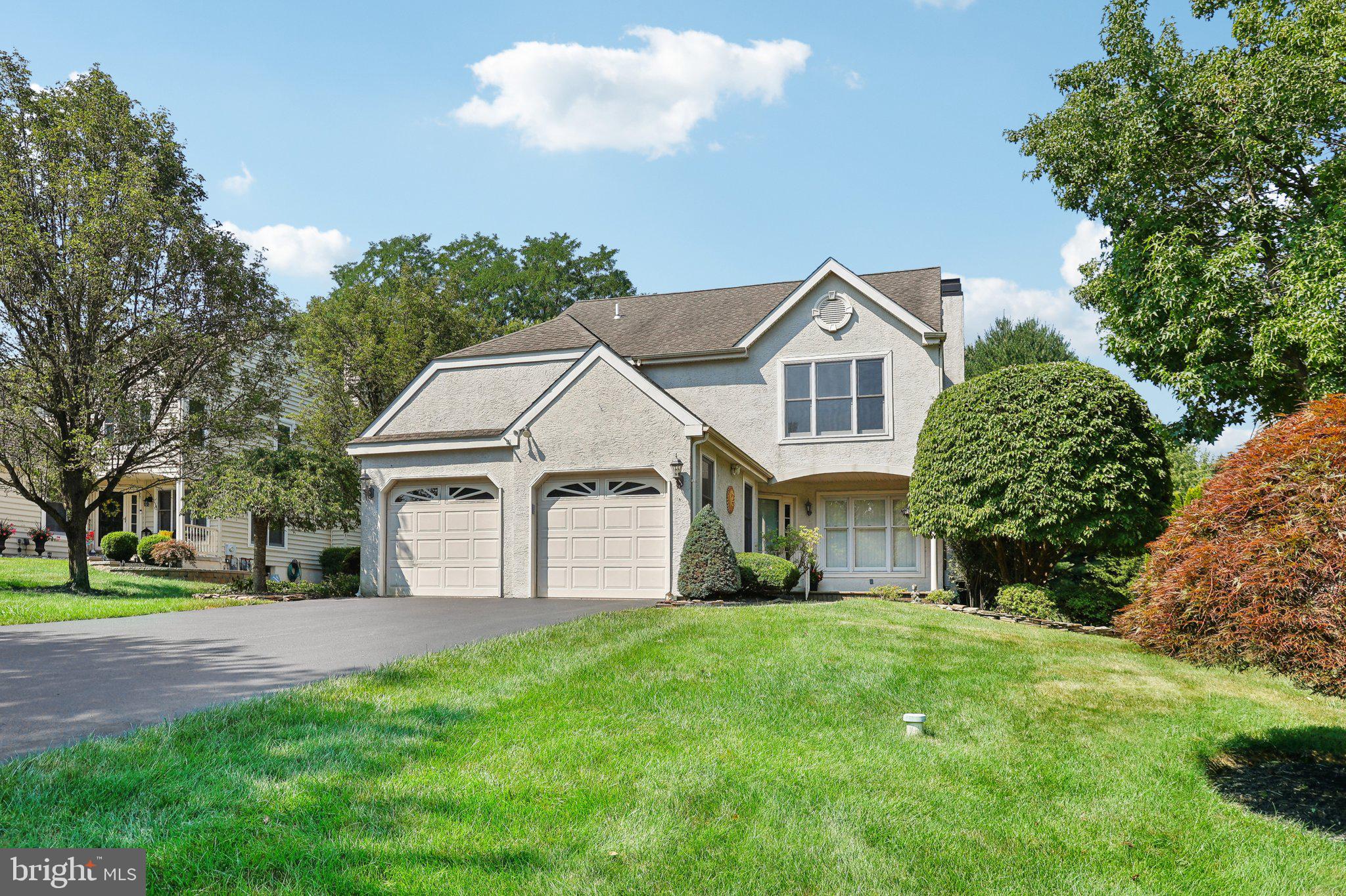 a front view of a house with a garden and plants