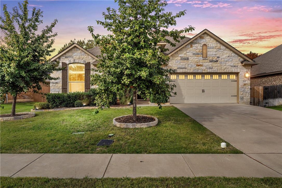 a front view of a house with a yard and garage