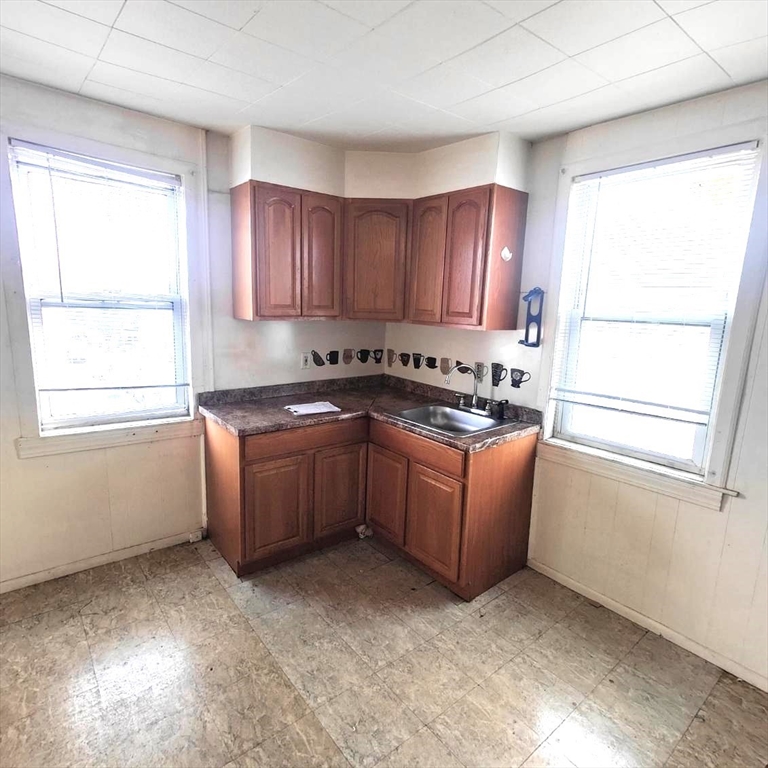 a kitchen with sink a window and cabinets