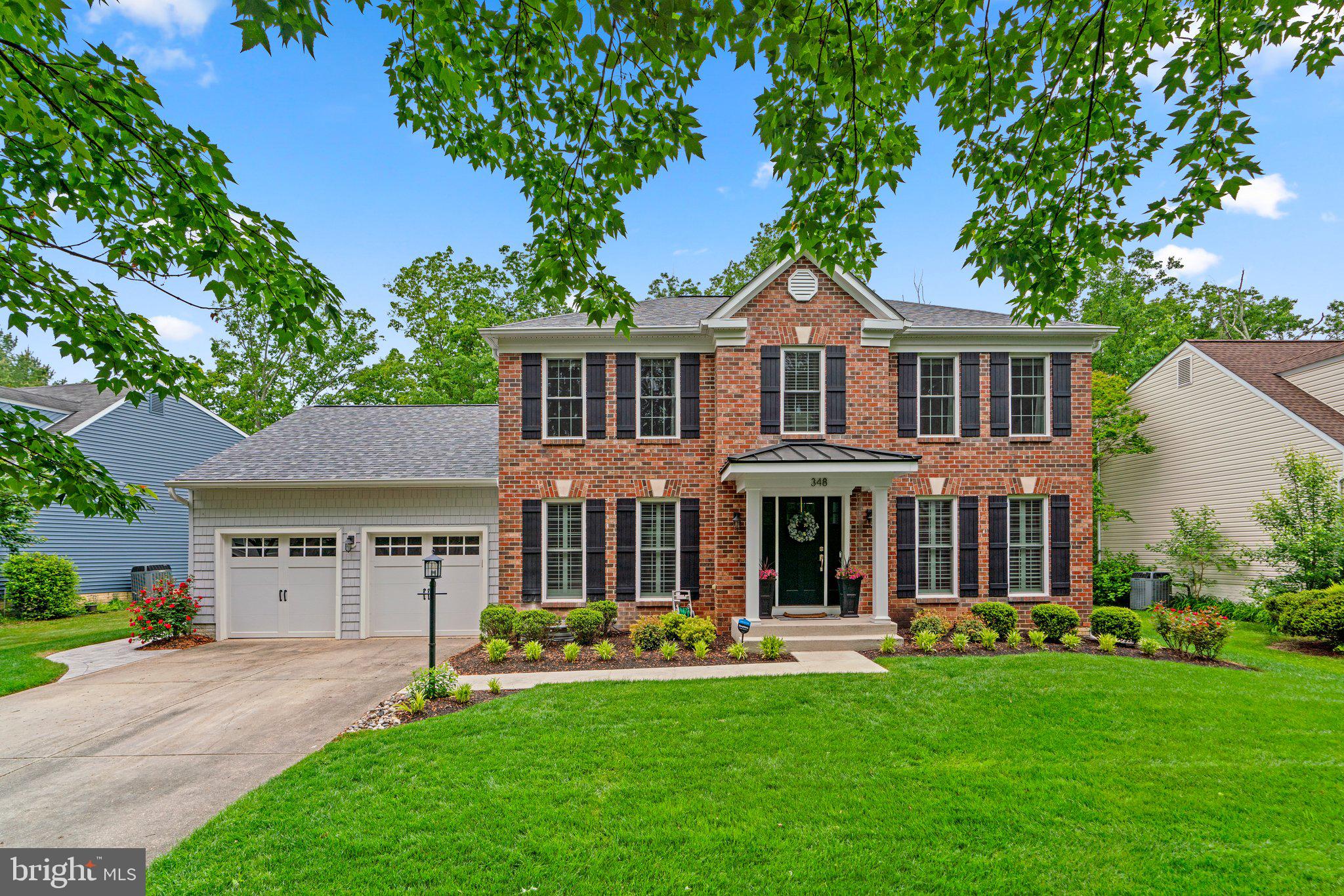 a front view of a house with yard and green space