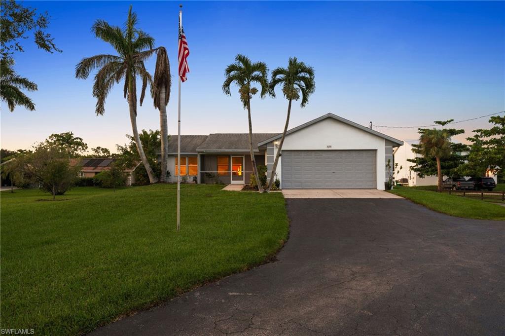 a view of a house with a yard and palm tree