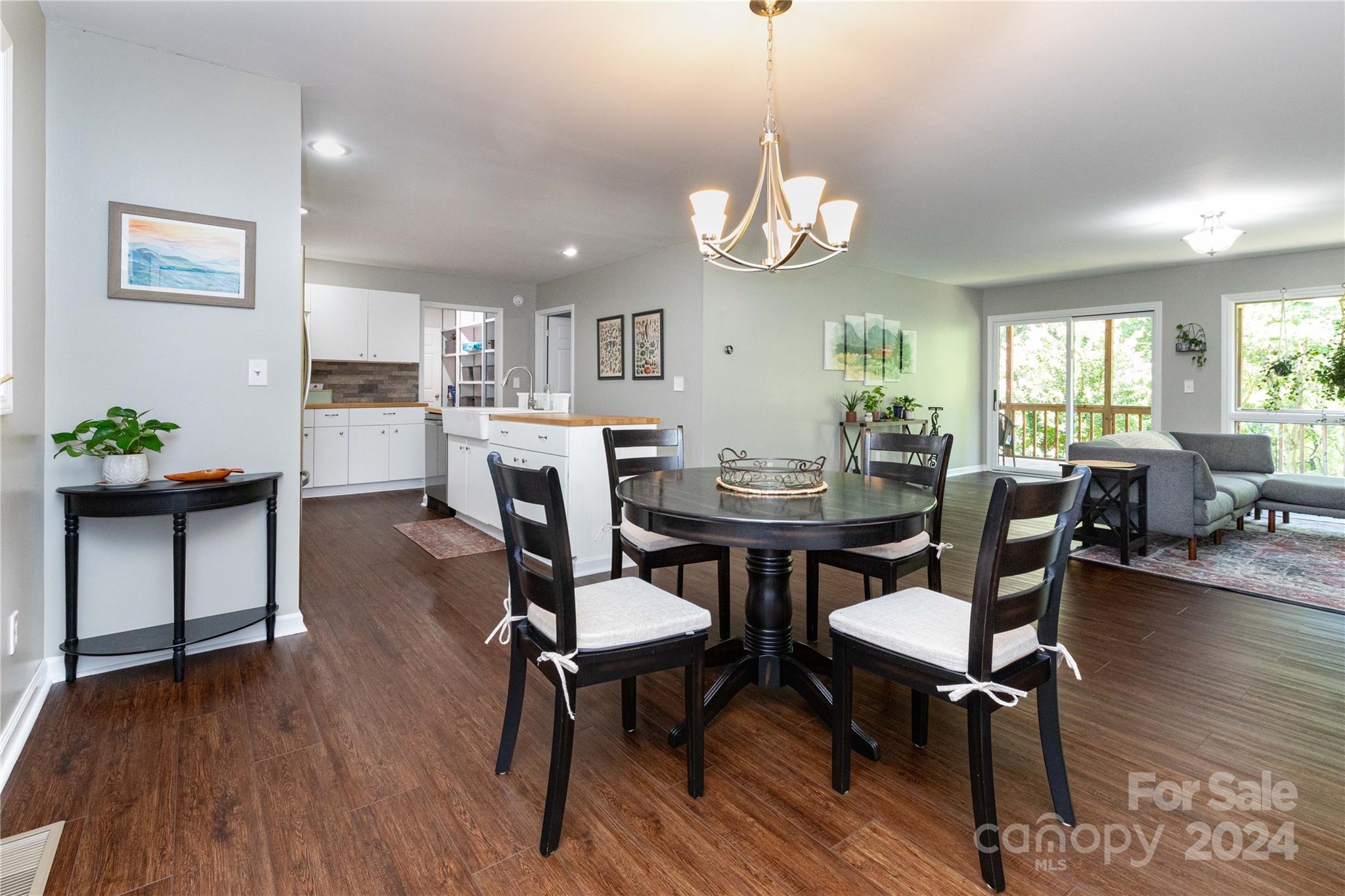 a view of a dining room with furniture a chandelier and wooden floor