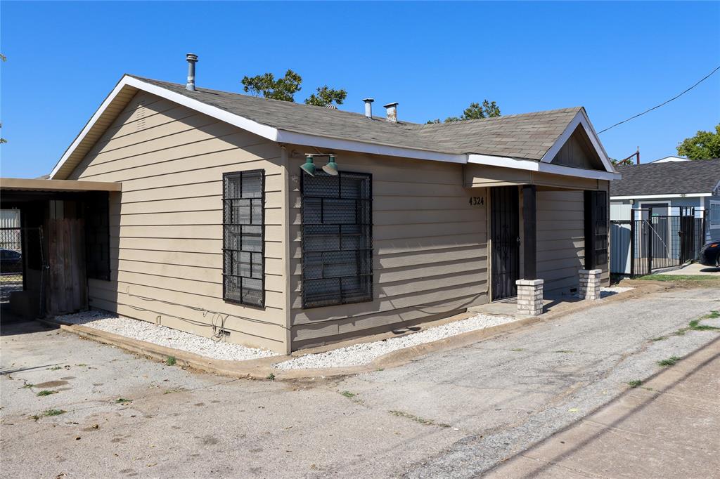 a view of a house with a small yard and wooden fence