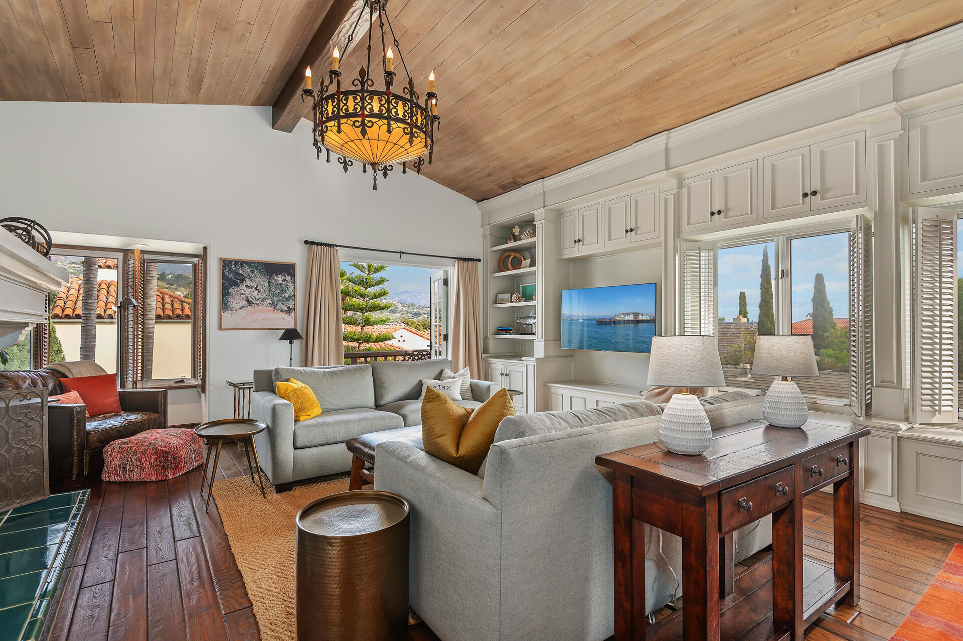 a living room with furniture a chandelier and a dining table