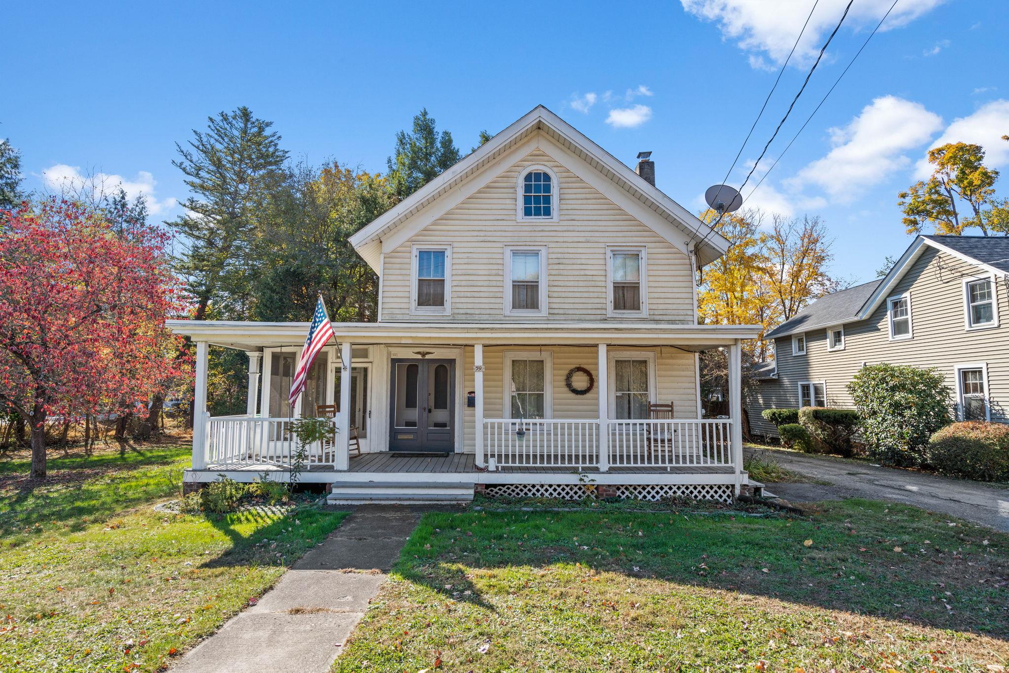 View of front of home with covered porch and a front lawn