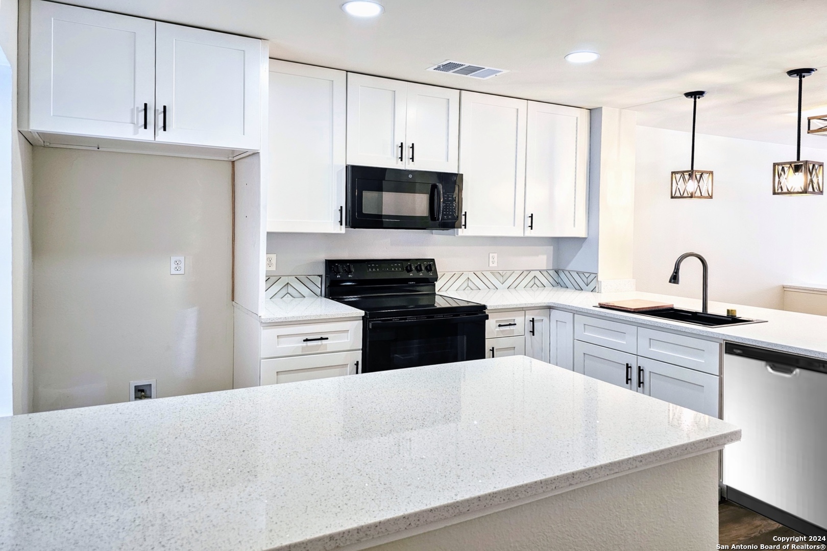 a kitchen with granite countertop white cabinets and white appliances