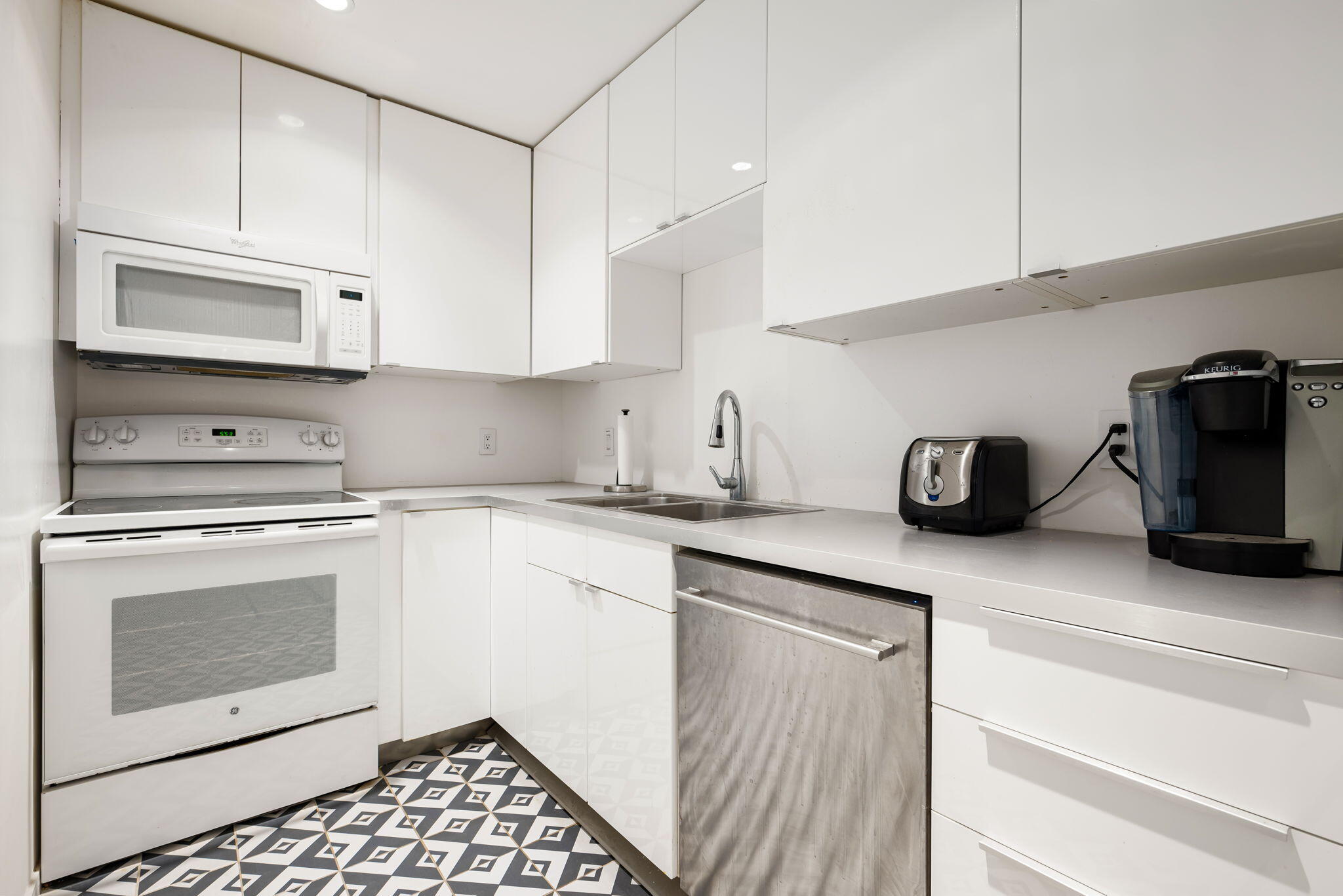 a kitchen with granite countertop a sink a stove and cabinets