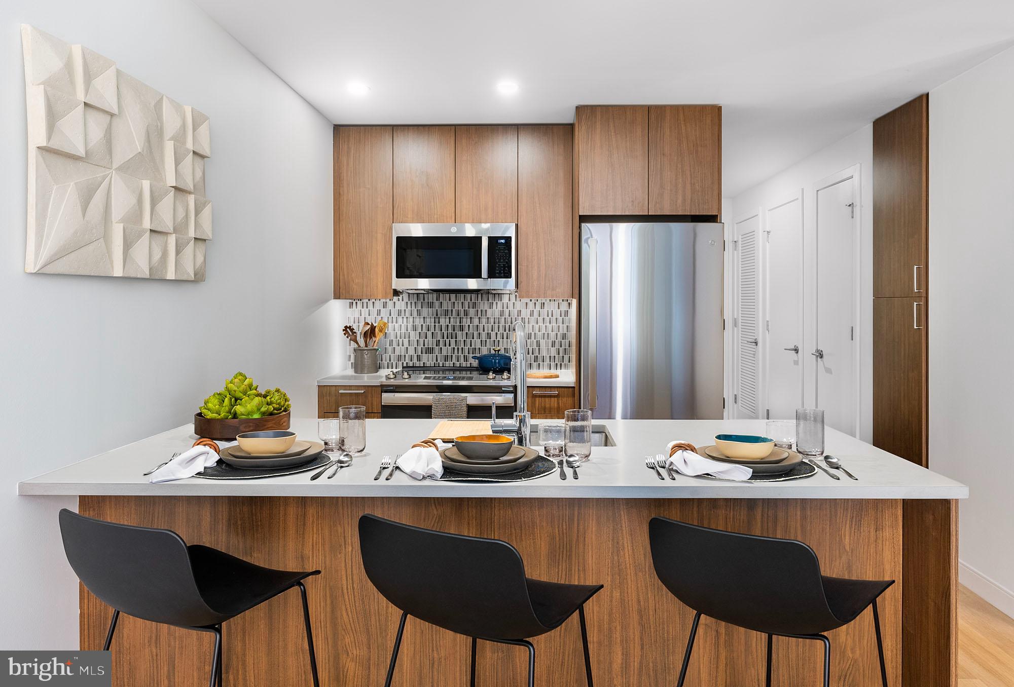 a kitchen with granite countertop a table chairs stove and refrigerator