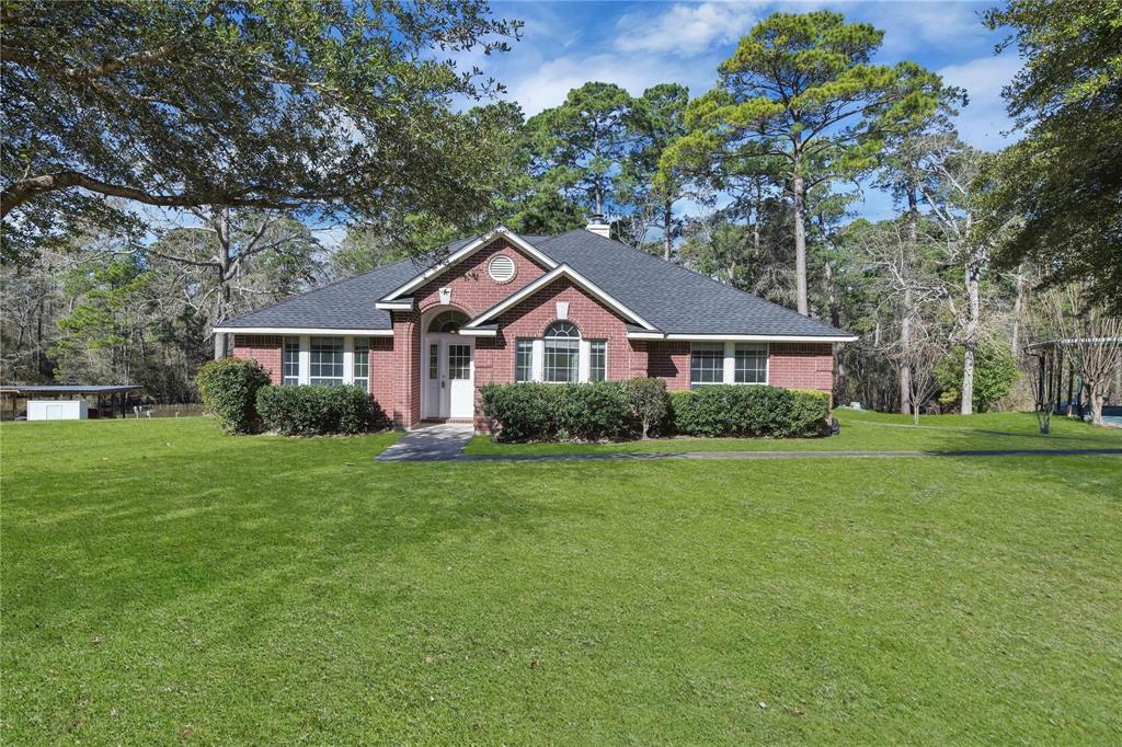 a front view of a house with a yard and trees