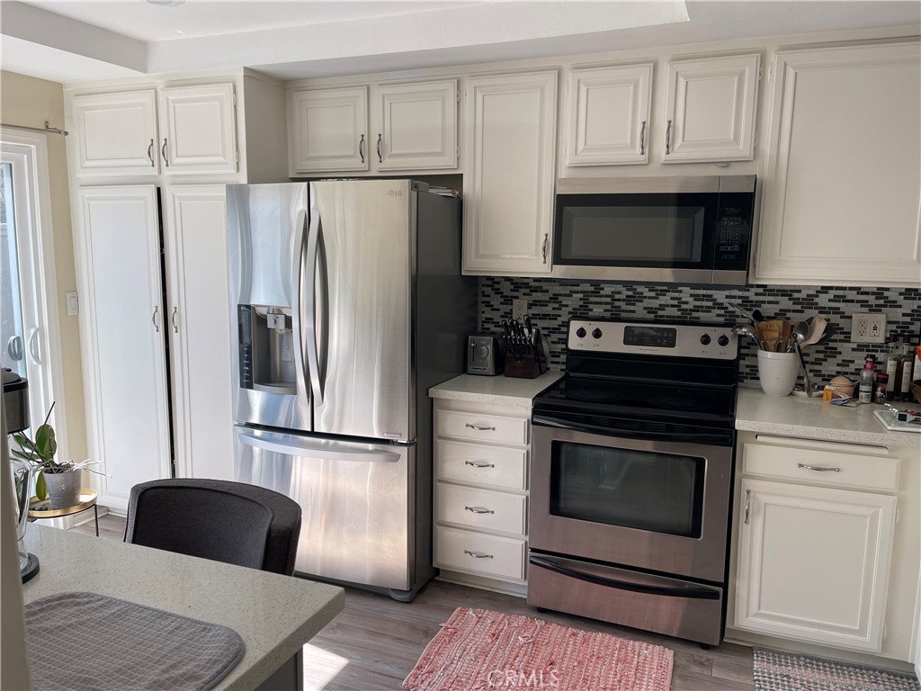 Kitchen with white cabinets and statnless steel appliances