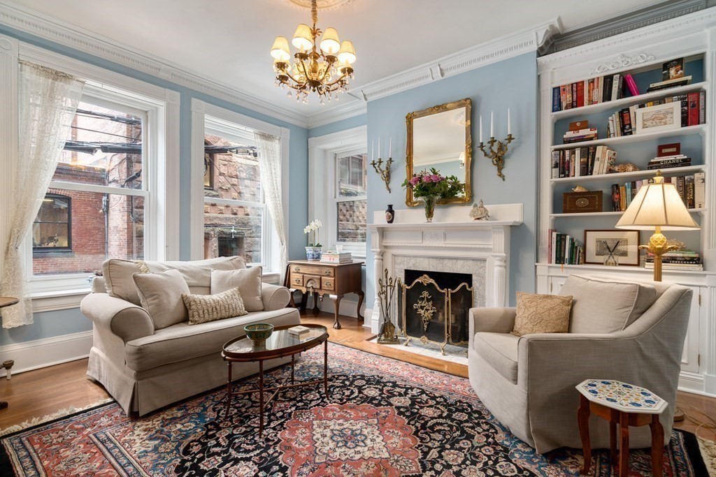 a living room with furniture fireplace and a large window