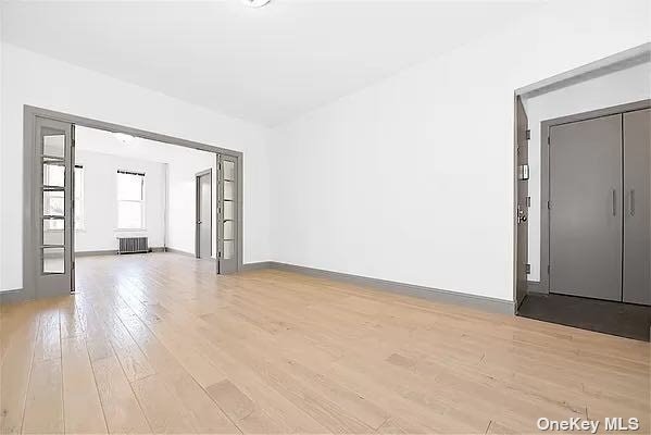 a view of an empty room with wooden floor